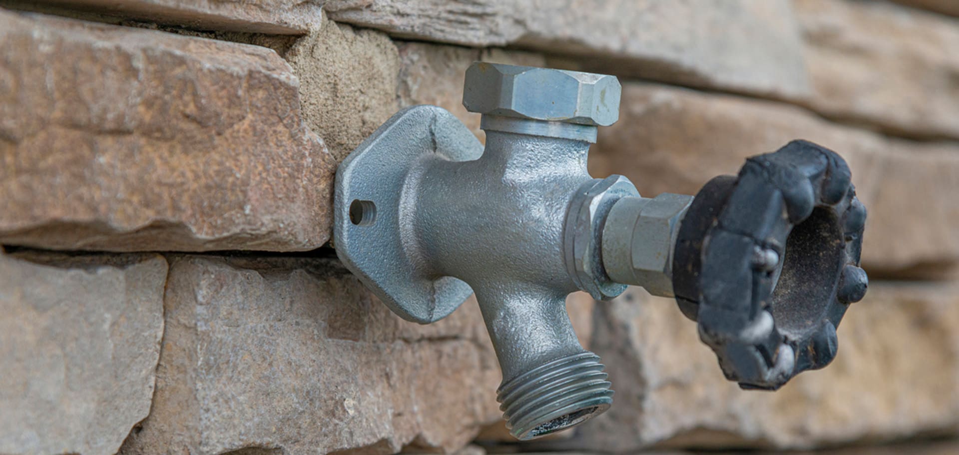 installing hose bib outdoor faucets on stone walls